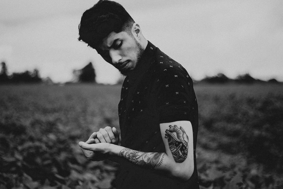 black-and-white man black heart tattoo on left arm tattoo