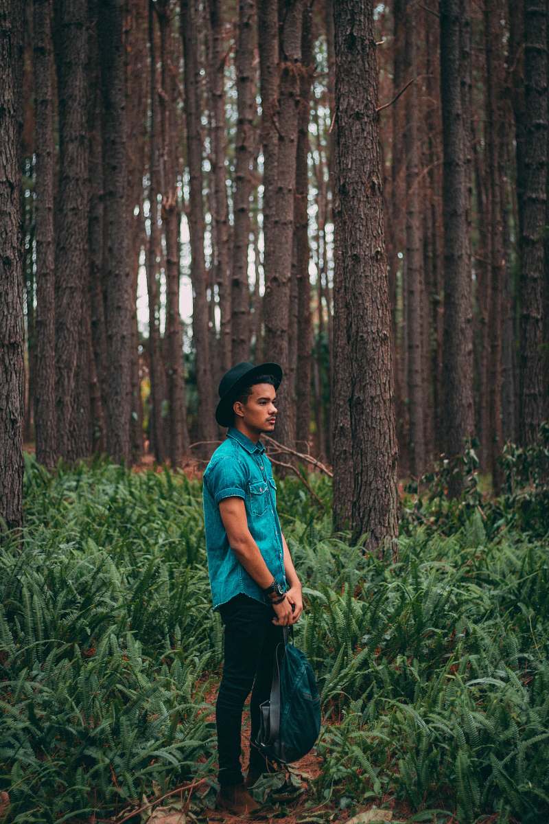 person man standing in the middle of forest during daytime human