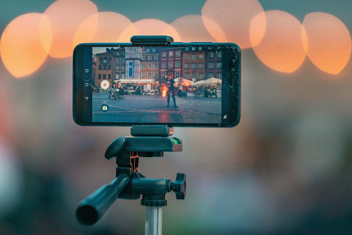 photo bokeh photography of a smartphone showing picture of the city street tripod