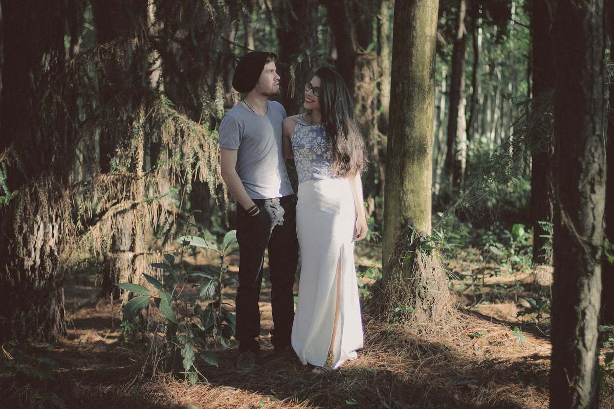 human man and woman standing together surrounded by green trees and plants during daytime people