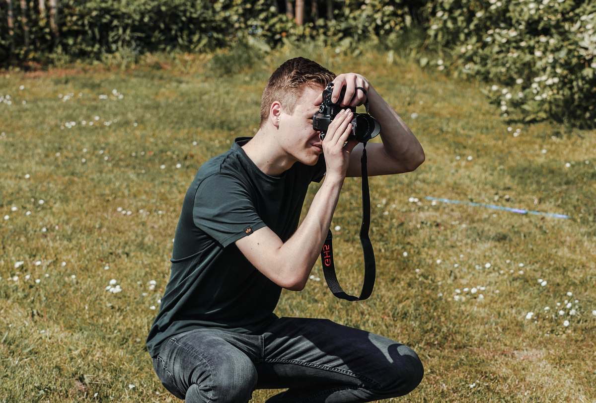 human man holding black DSLR camera photographer