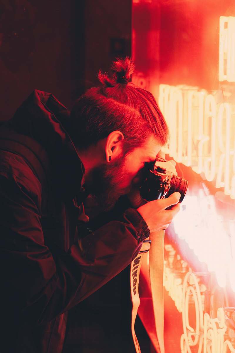 human man taking photo of red LED neon signage photographer