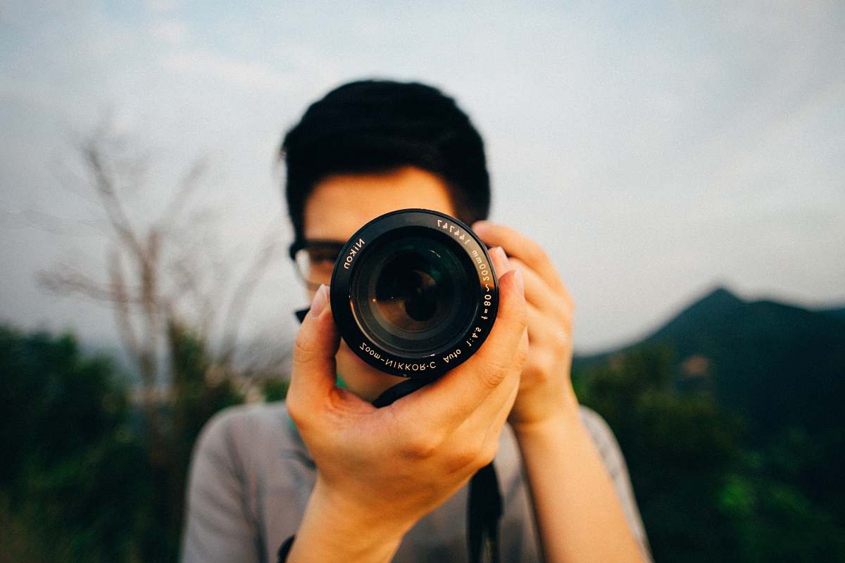 human man using DSLR camera people