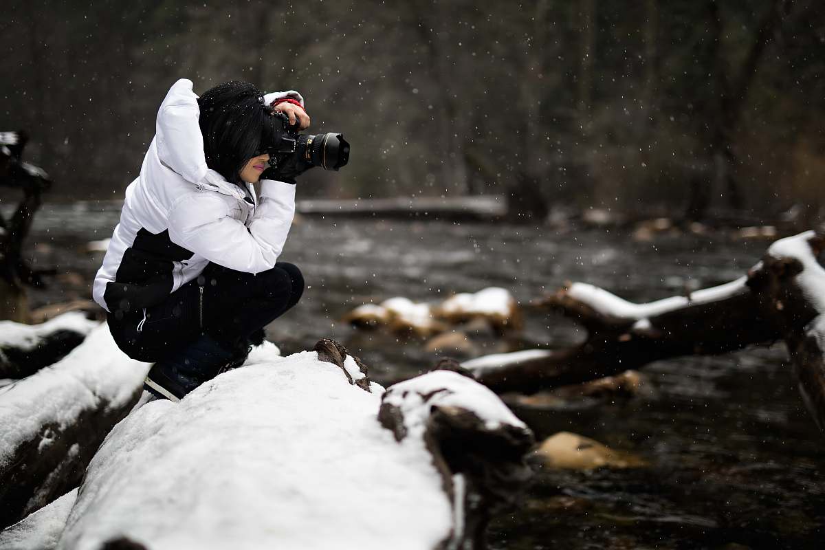 human person holding camera on snow-covered surface photography
