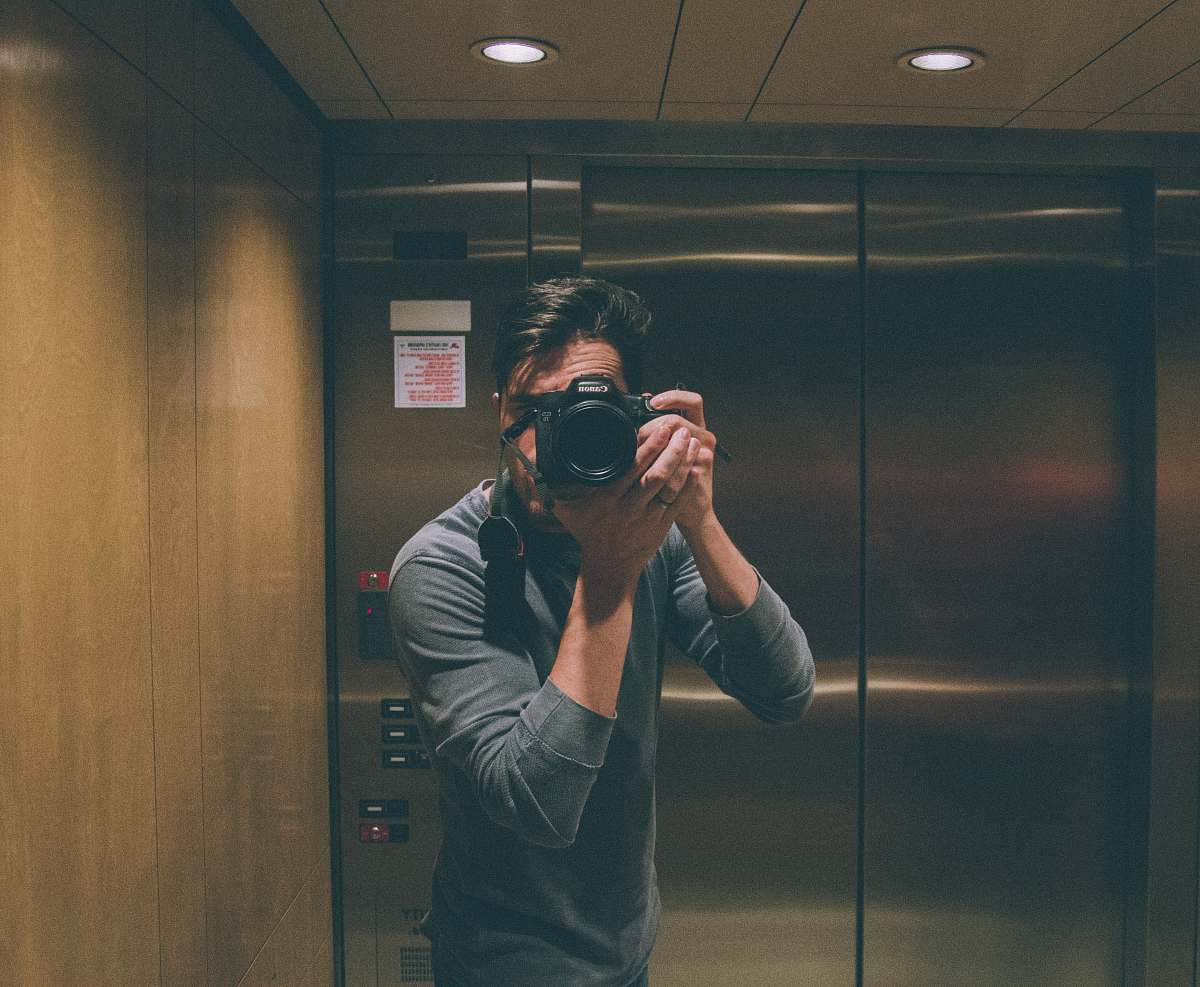human person holding DSLR camera elevator