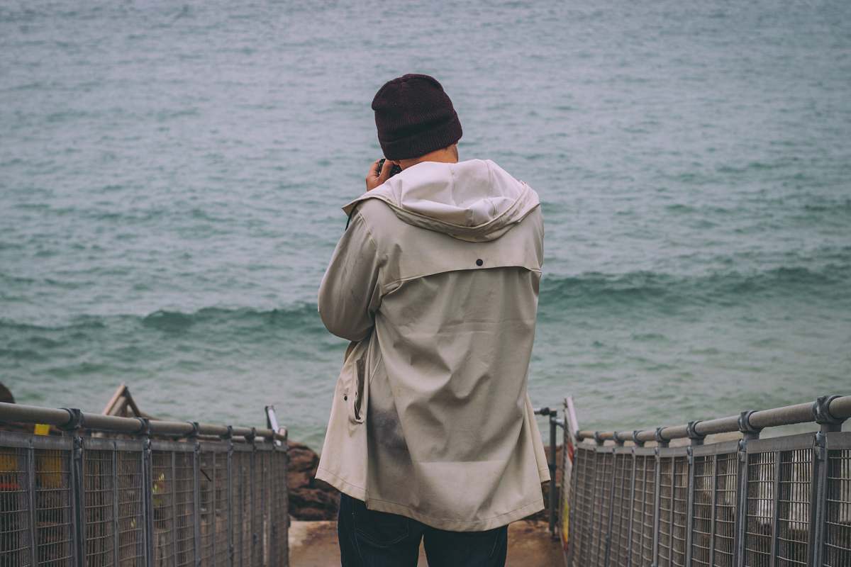 people person standing on pathway near sea beach