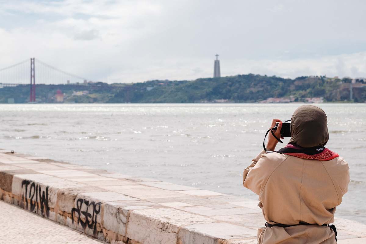 human person taking photo of Golden Gate bridge in front of body of water photographer