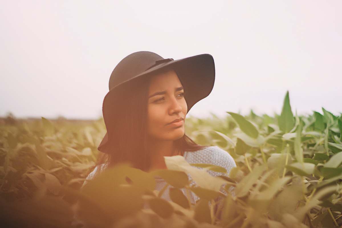 human photo of a woman taking a photo in the middle of green leaves woman