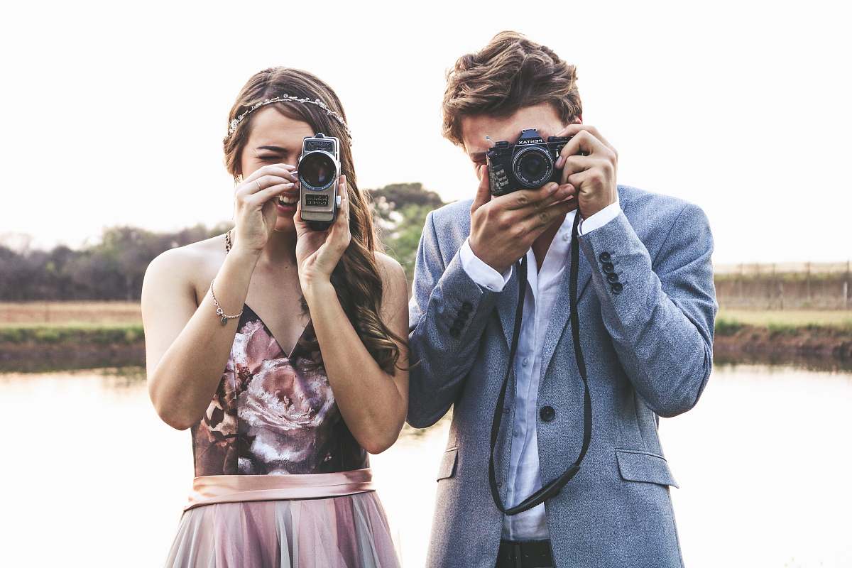 human woman and man holding cameras mobile phone