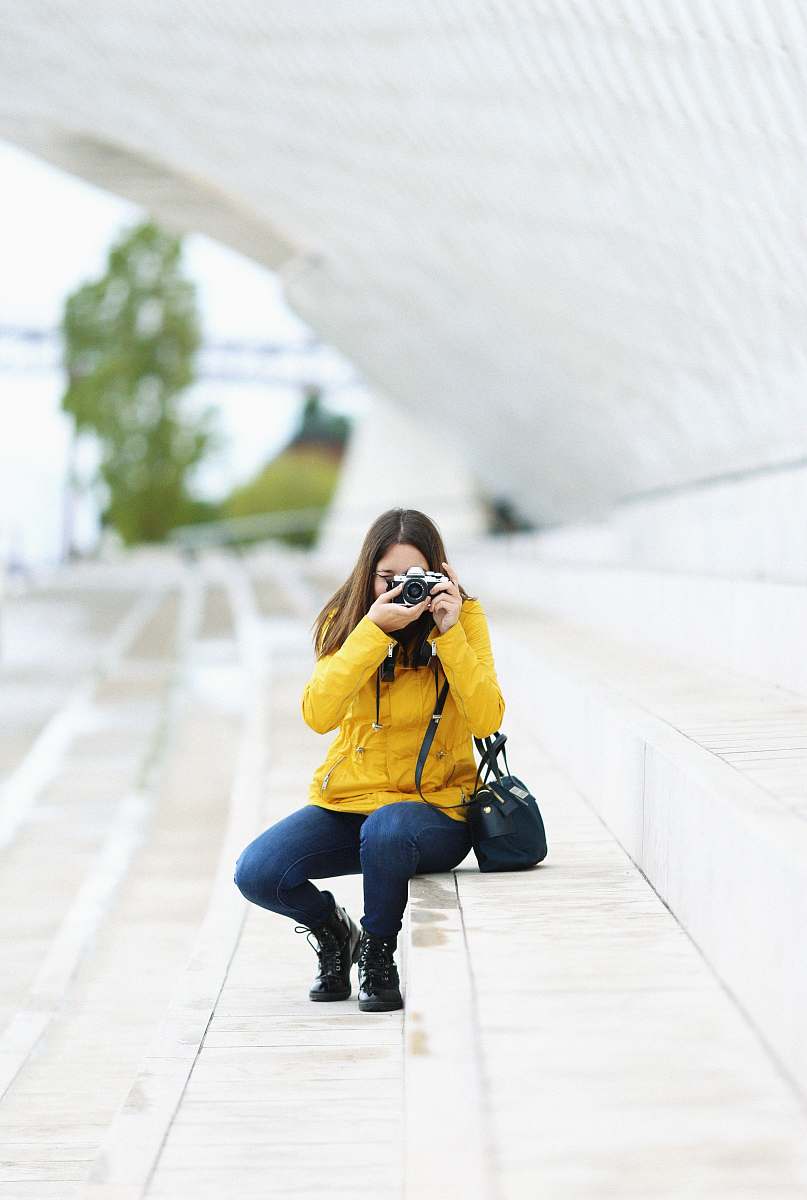 human woman sitting on stair and capturing photo apparel