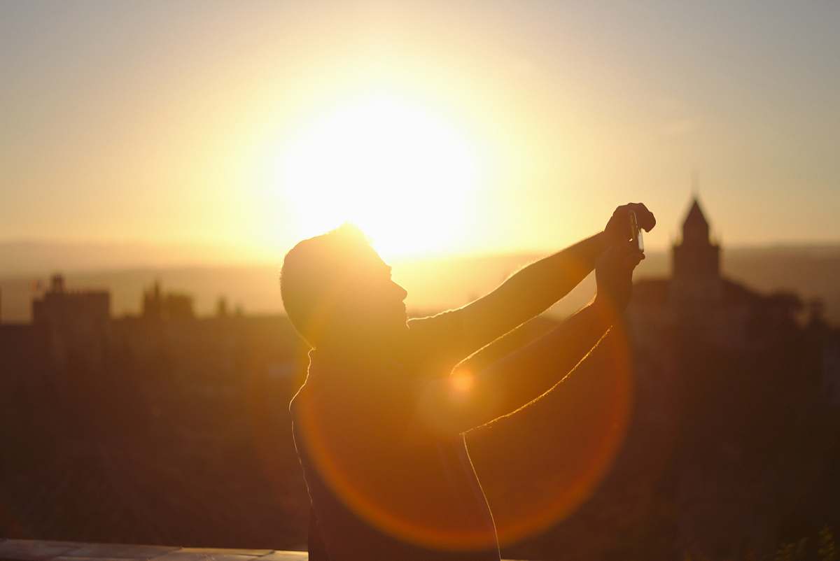 alhambra man raising hands under sunset granada
