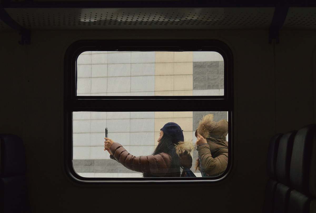 russia woman taking photo outside train person