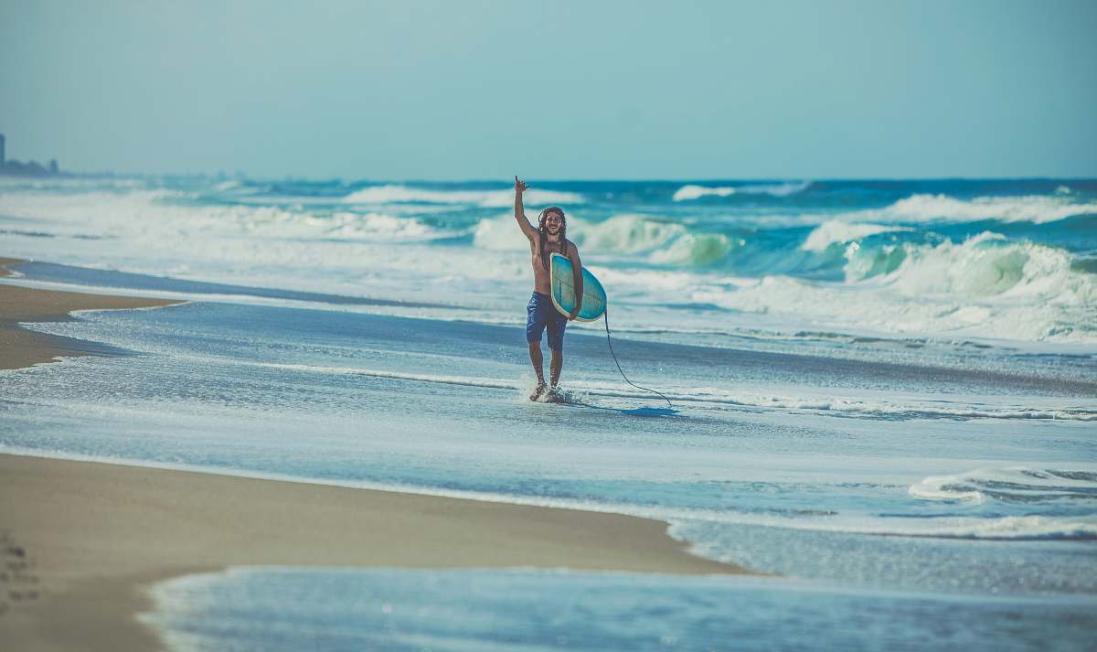 water man carrying surfboard at beach ocean