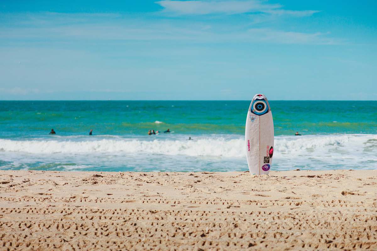 sea white surfboard vertically standing on seashore ocean