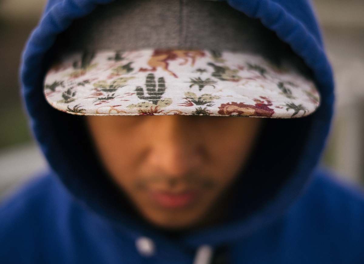detail close up photo of white, green, and red floral cap cap