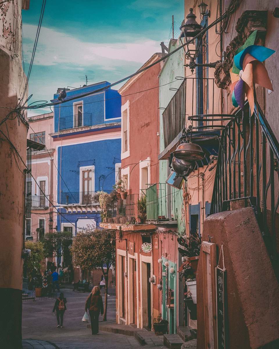 path people walking near houses during daytime walkway