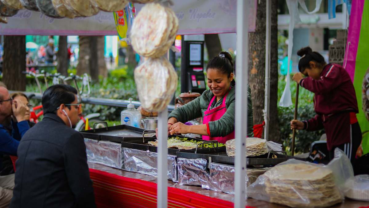 human woman cooking front of man watching over mexico city