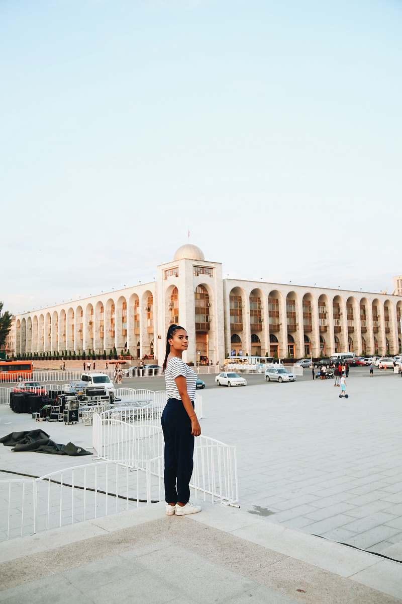human woman standing front of concrete building at daytime building