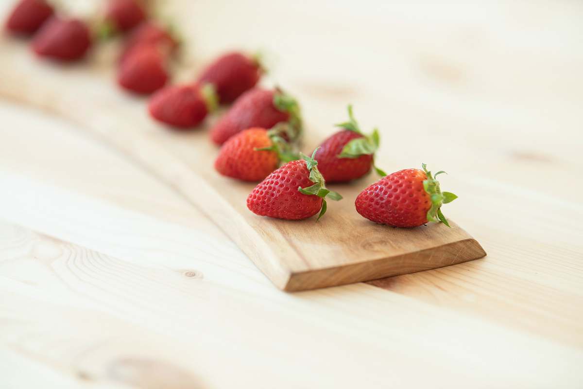 food red strawberries on brown wooden chopping board strawberry