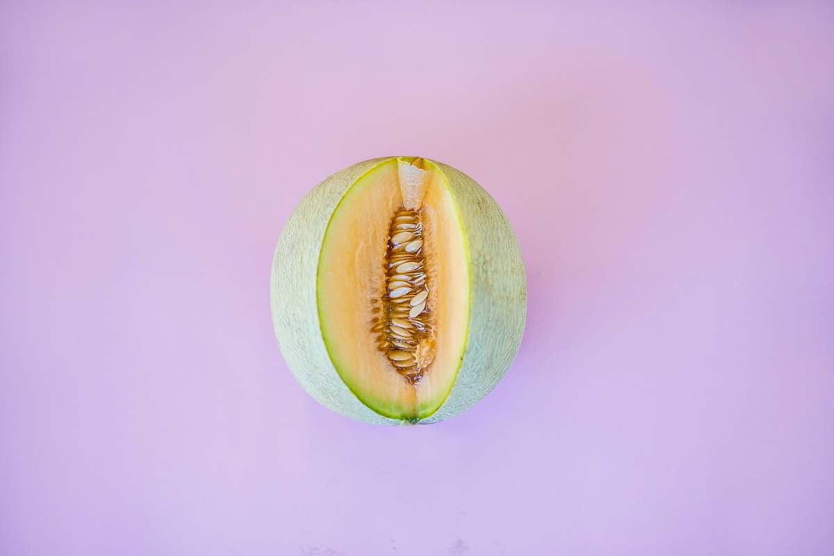 food sliced green fruit on pink surface melon