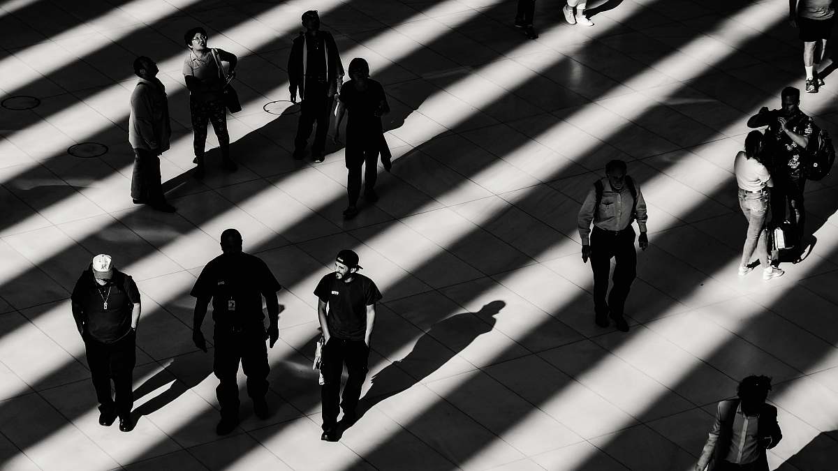 walking grayscale photo of people on white pavement railing
