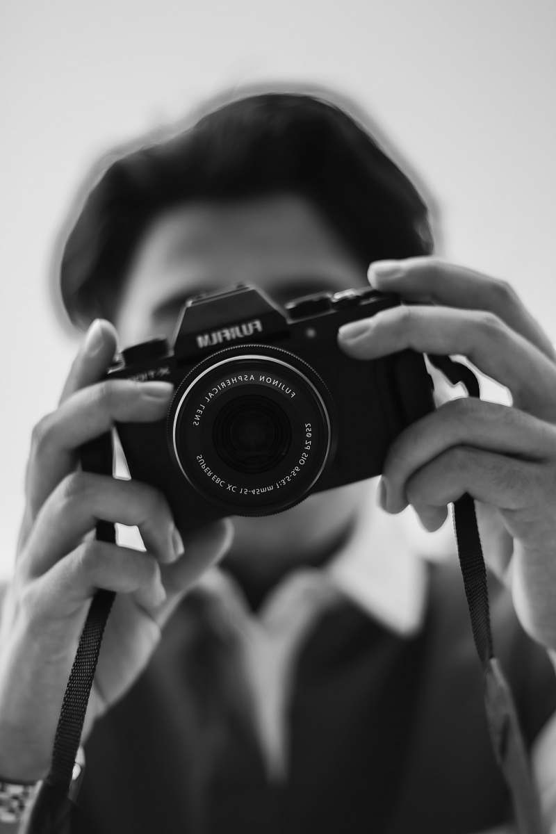 camera person holding Fujifilm camera electronics