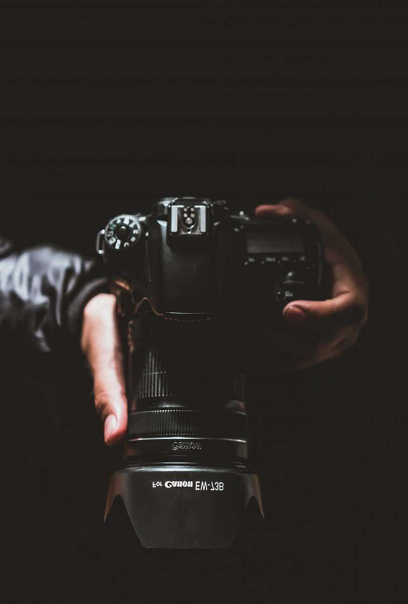 electronics person holding black Canon DSLR camera photo