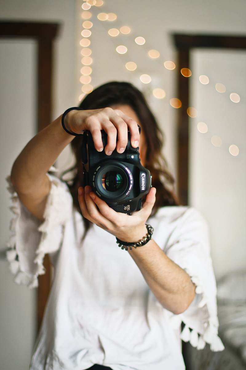 person woman holding black DSLR camera human