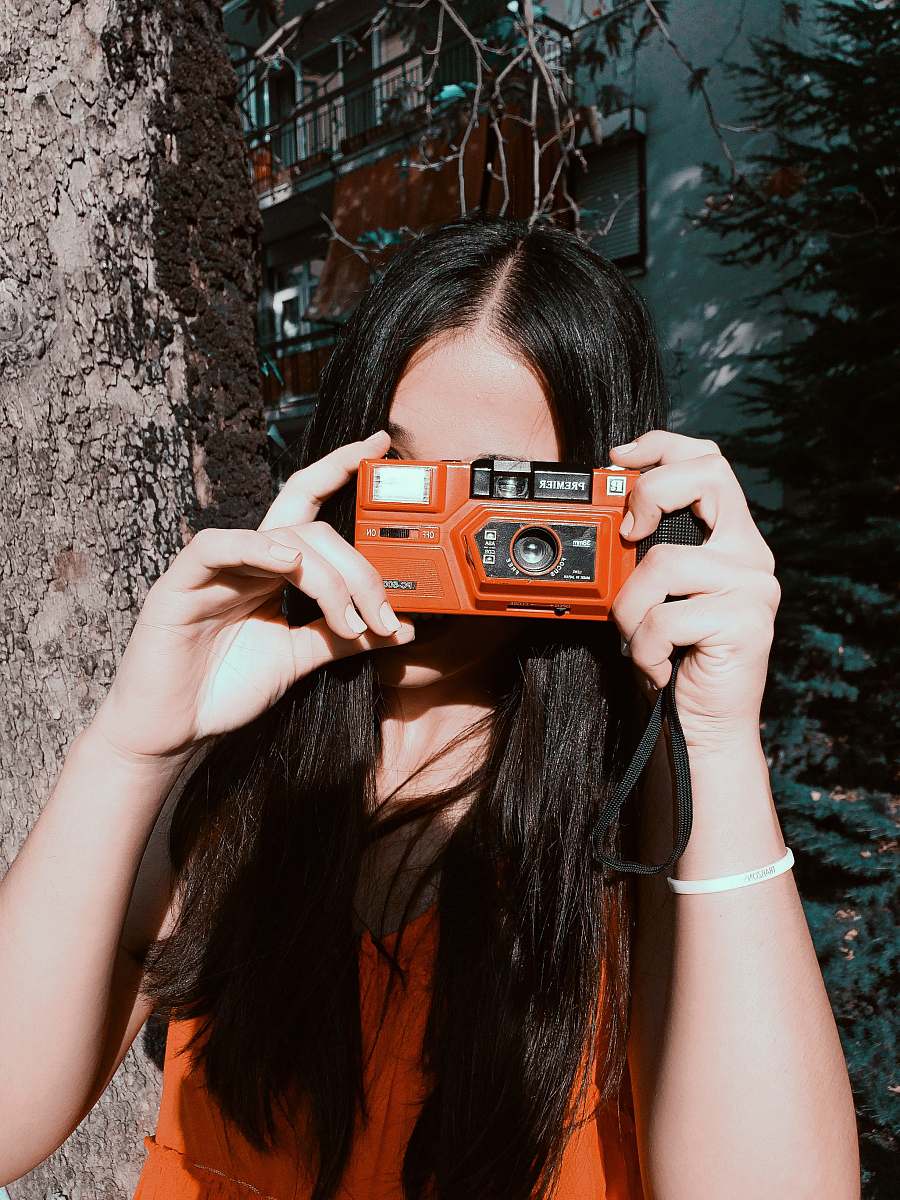 person woman holding orange camera human