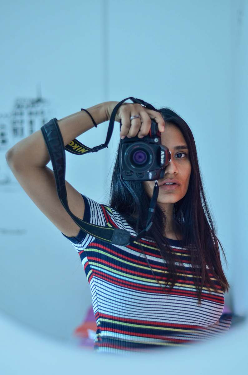 human woman in striped t-shirt holding camera person