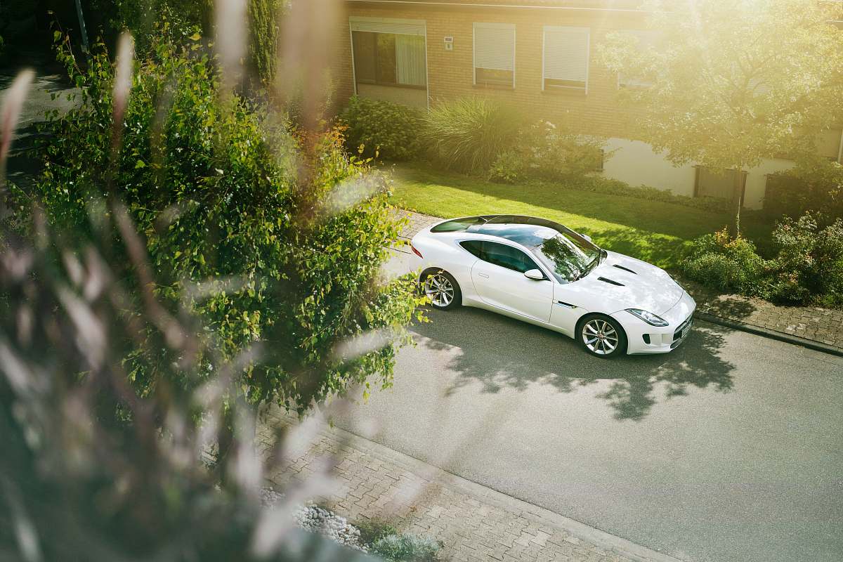 automobile white coupe parked near house sports car