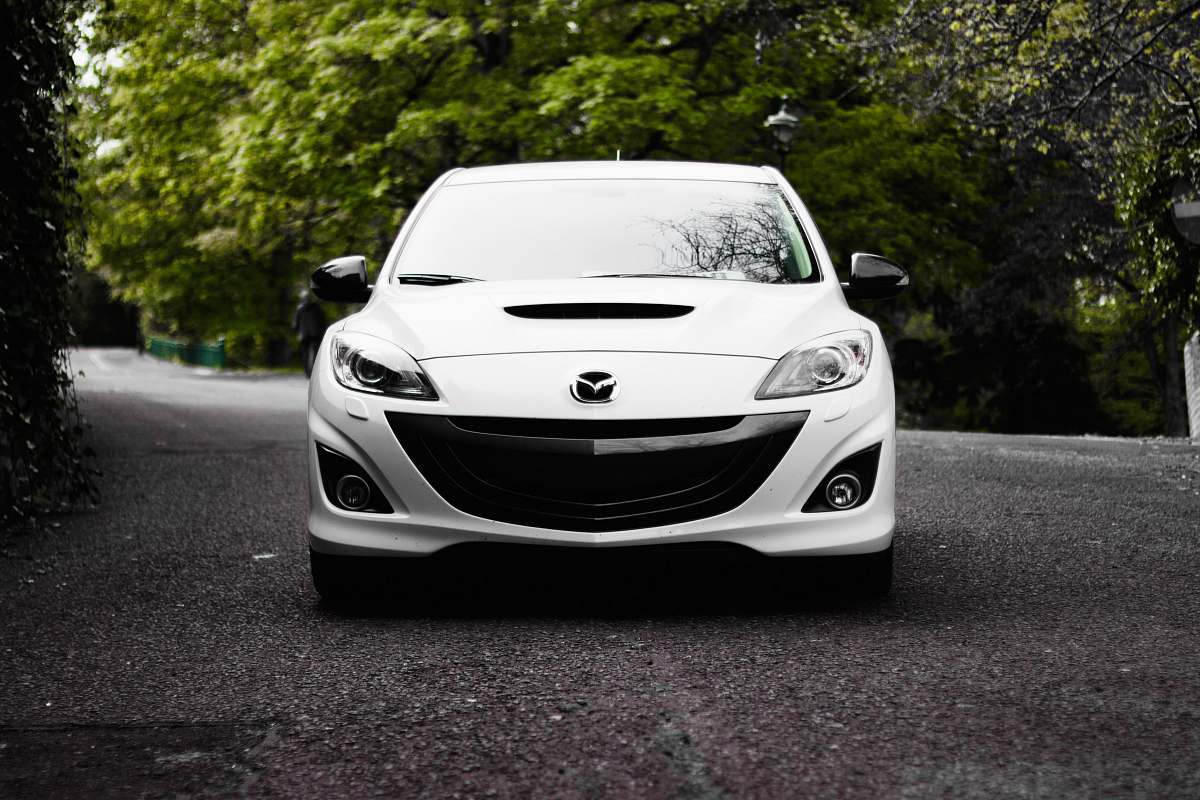 automobile white Mazda vehicle on road near tree vehicle