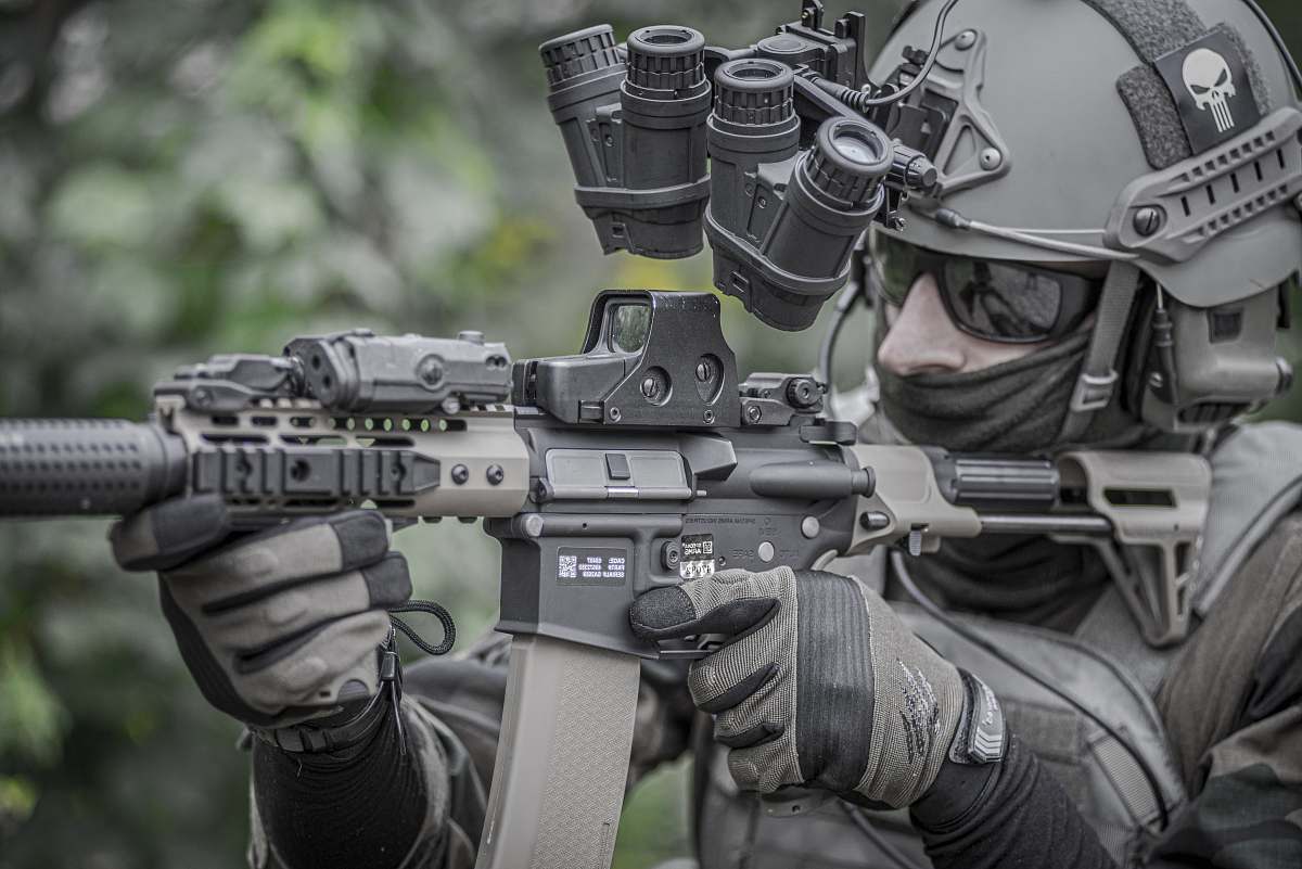 military person holding grey and black rifle clothing