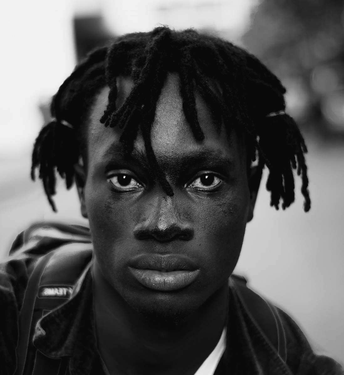 black-and-white gray scale photo of man with dread lock hair face
