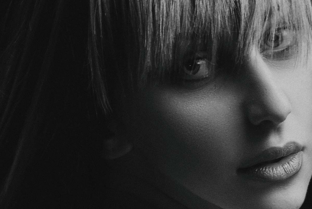 black-and-white greyscale photo of woman with bangs face