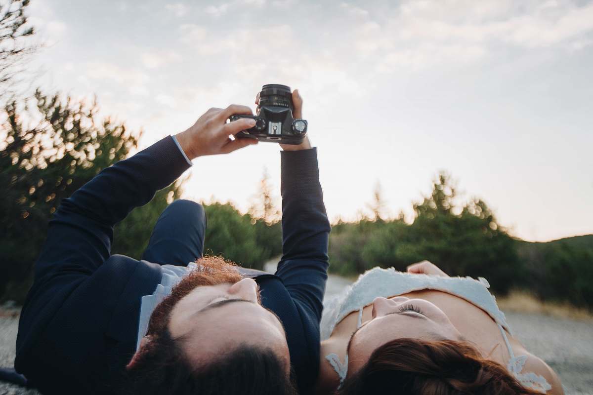person man and woman lying on ground camera