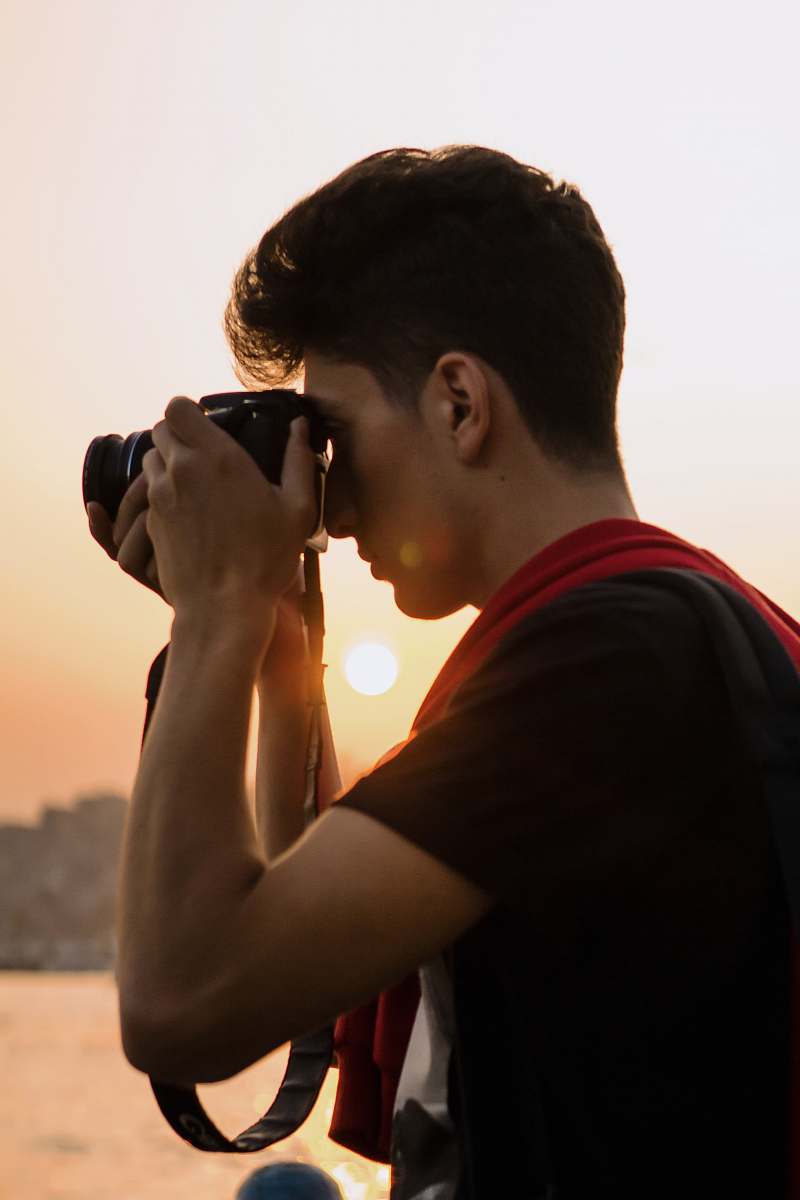 person man holding DSLR camera photo