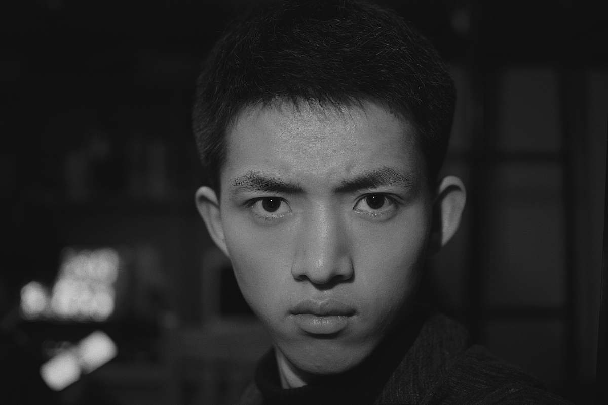 face man inside dark room black-and-white