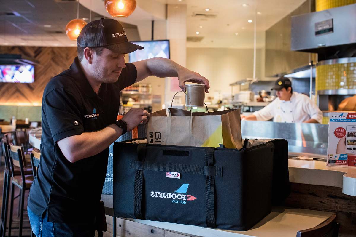 person man putting cup into brown bag apparel