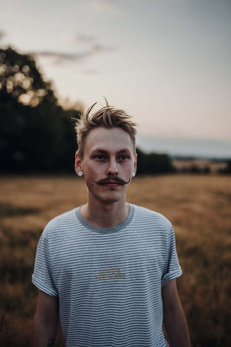 person man standing near trees at daytime apparel
