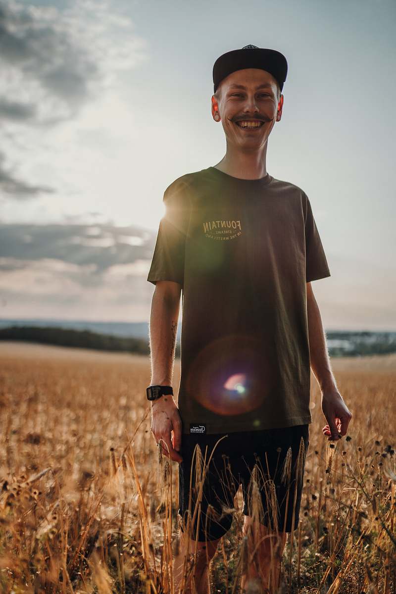 person man standing on wheat field clothing
