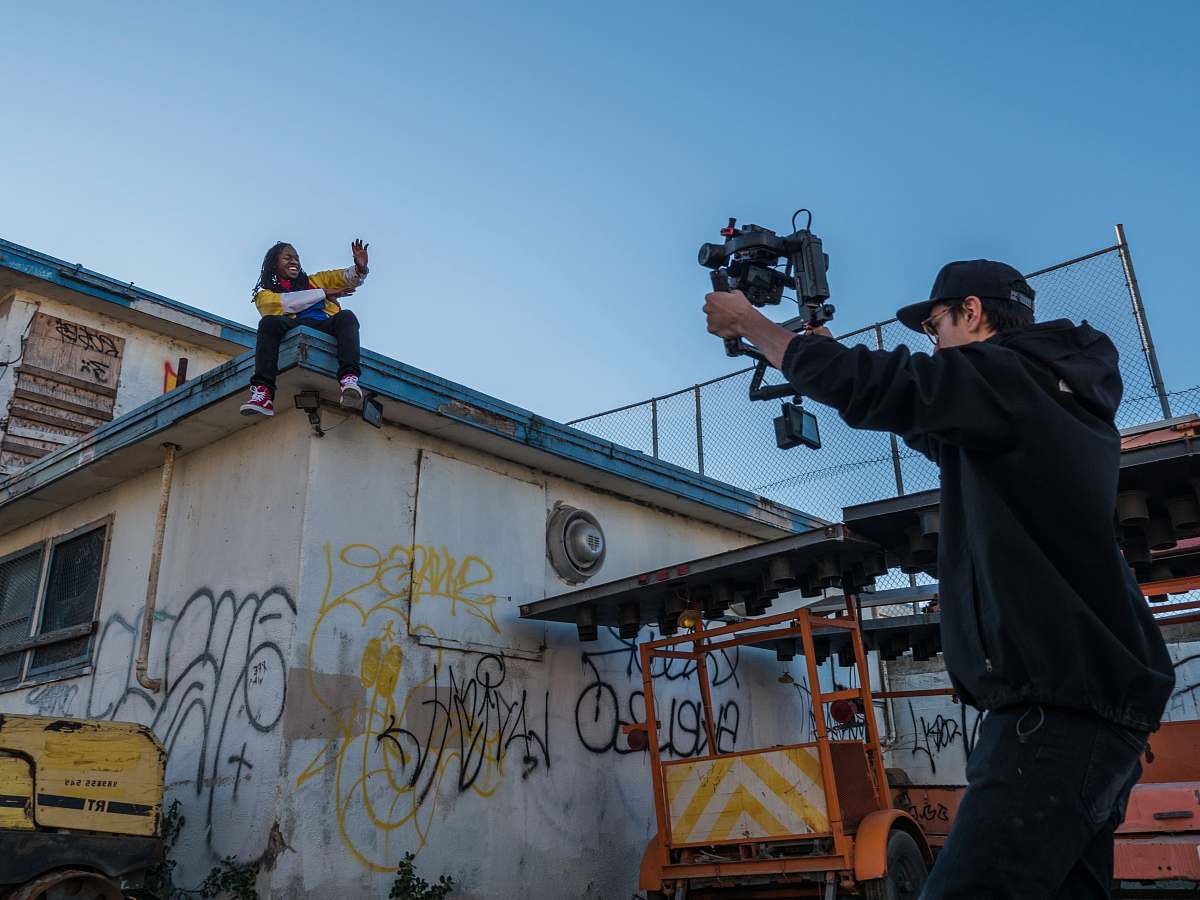 person man taking a video of a person on roof photographer