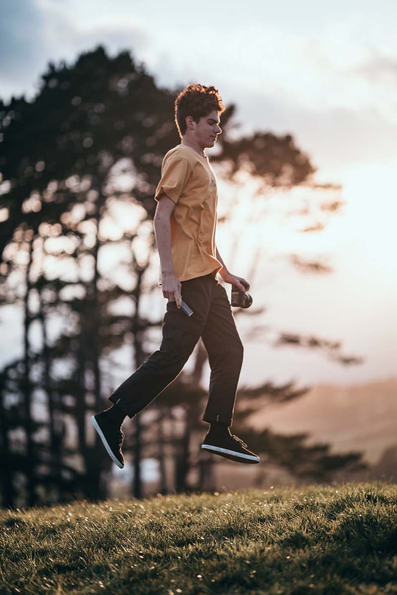 apparel shallow focus photo of man in brown T-shirt jumping clothing