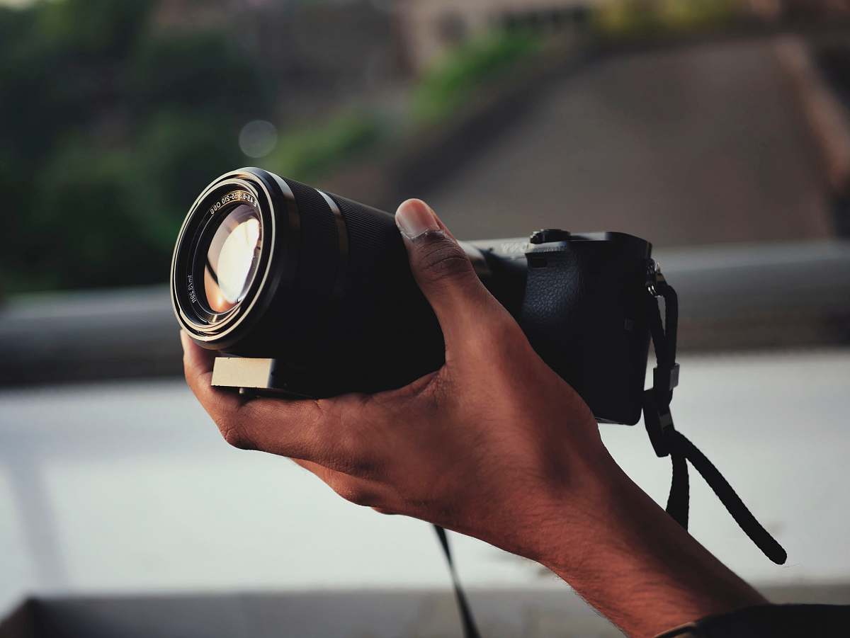 person shallow focus photography of black DSLR camera electronics