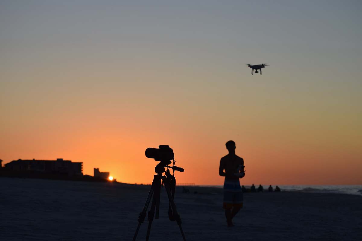 person topless man standing near the video camera tripod