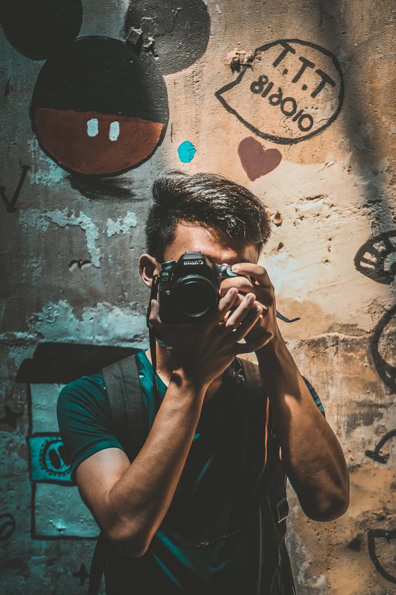 person unknown person holding black Canon DSLR camera camera