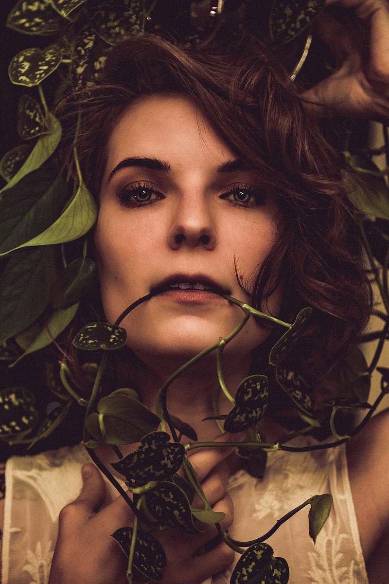person woman beside plants face