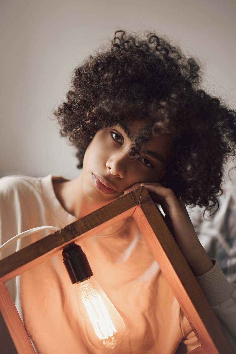 person woman holding brown wooden framed light bulb people