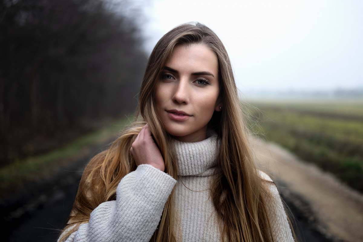 person woman holding he hair face