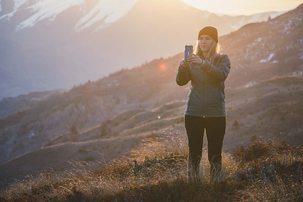 person woman standing on the grass field using smartphone standing